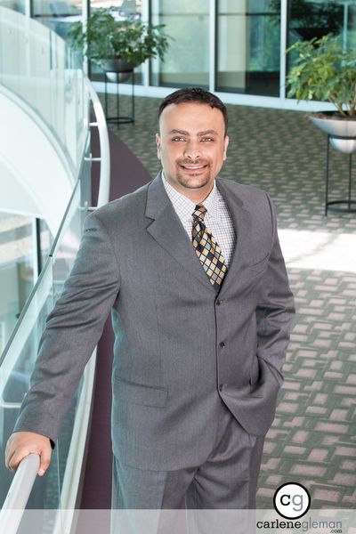 Executive portrait of a man in a gray suit in a modern office lobby