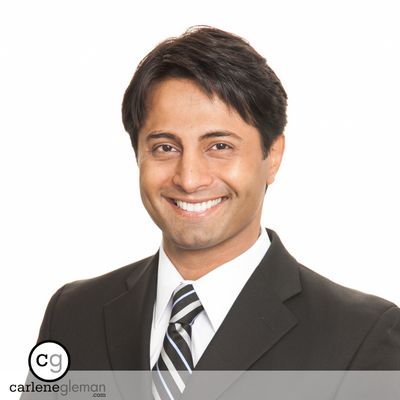 Professional business headshot of a man in a dark suit and striped tie