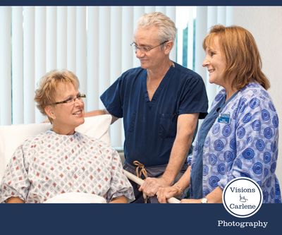 Doctor and nurse speaking with a seated patient in a clinical setting