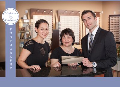 Three opticians staff members at the front desk of an eyewear practice